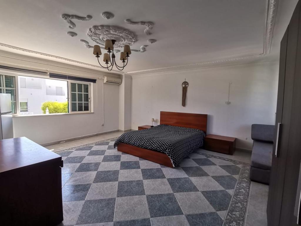 a bedroom with a bed and a checkered floor at Alma Rustica in Albufeira