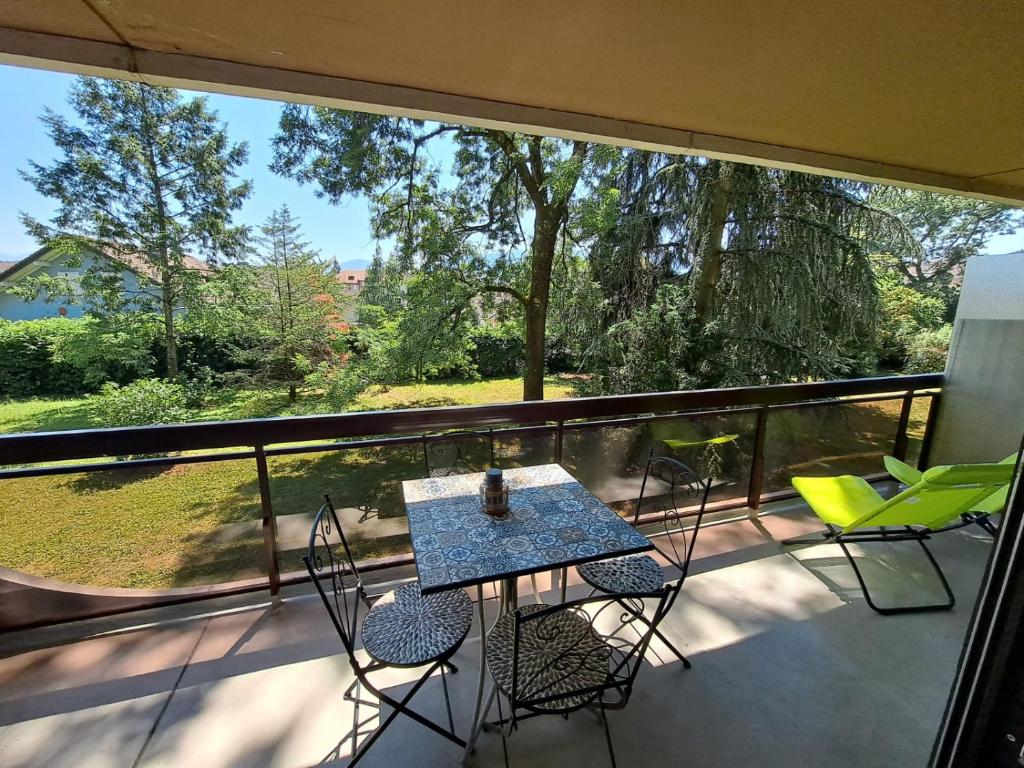 einen Balkon mit einem Tisch und Stühlen sowie einem großen Fenster in der Unterkunft Le Duc de Savoie Thonon in Thonon-les-Bains