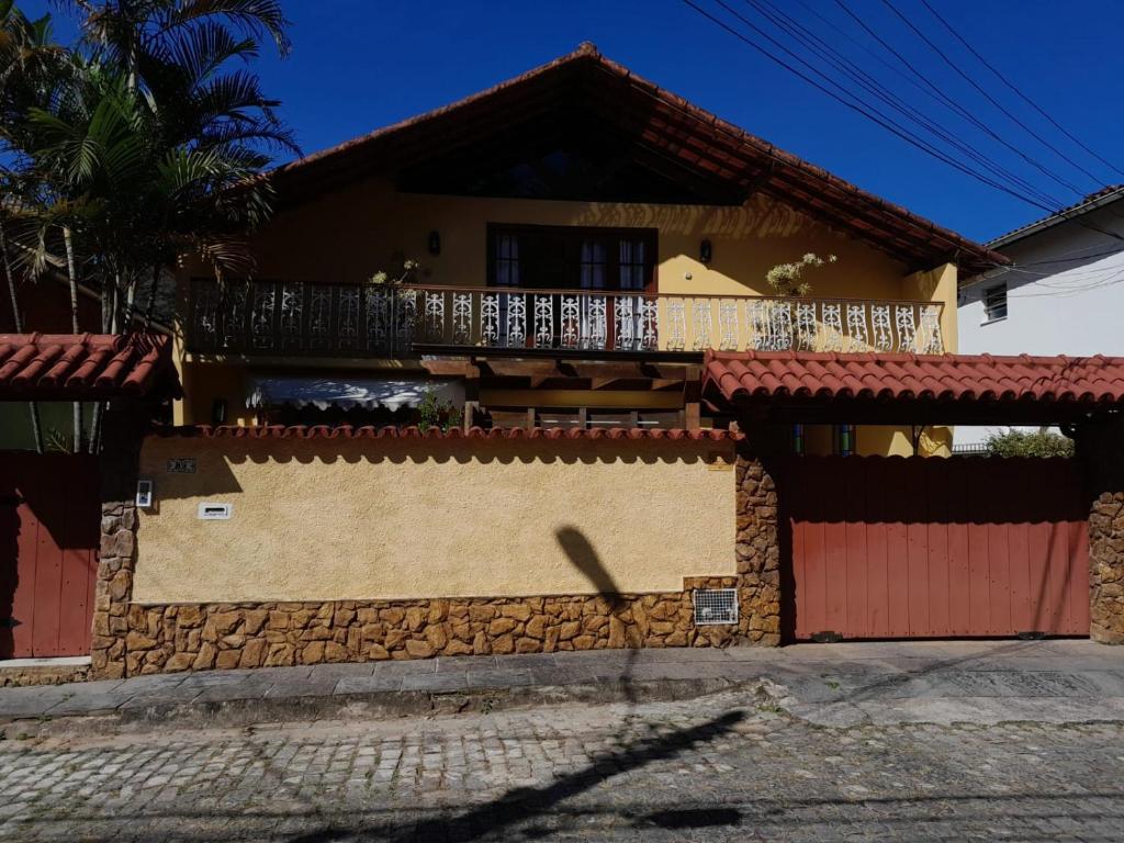una casa con una valla delante de ella en Loft da Beth na serra en Petrópolis