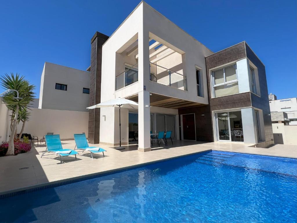 Villa con piscina y sillas azules en Villa Mil Palmeras, en Campoamor