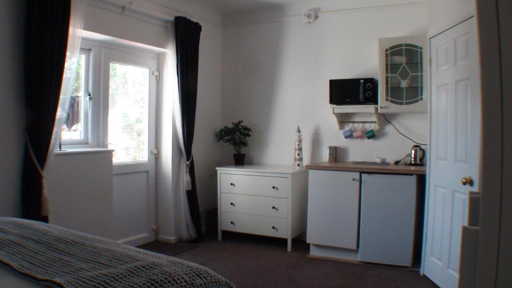 a bedroom with a bed and a dresser and a window at Vernon Lodge Flat 2 in Bournemouth