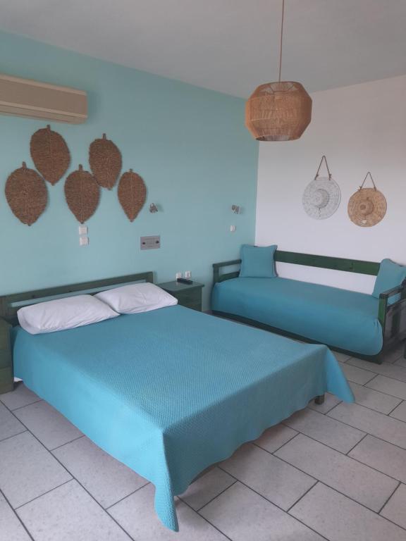 a bedroom with a blue bed and a wall with hearts on it at Kapares Studios in Agia Anna Naxos