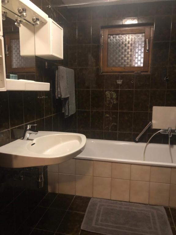 a bathroom with a sink and a bath tub at Holmes Café & Pension in Engelhartszell