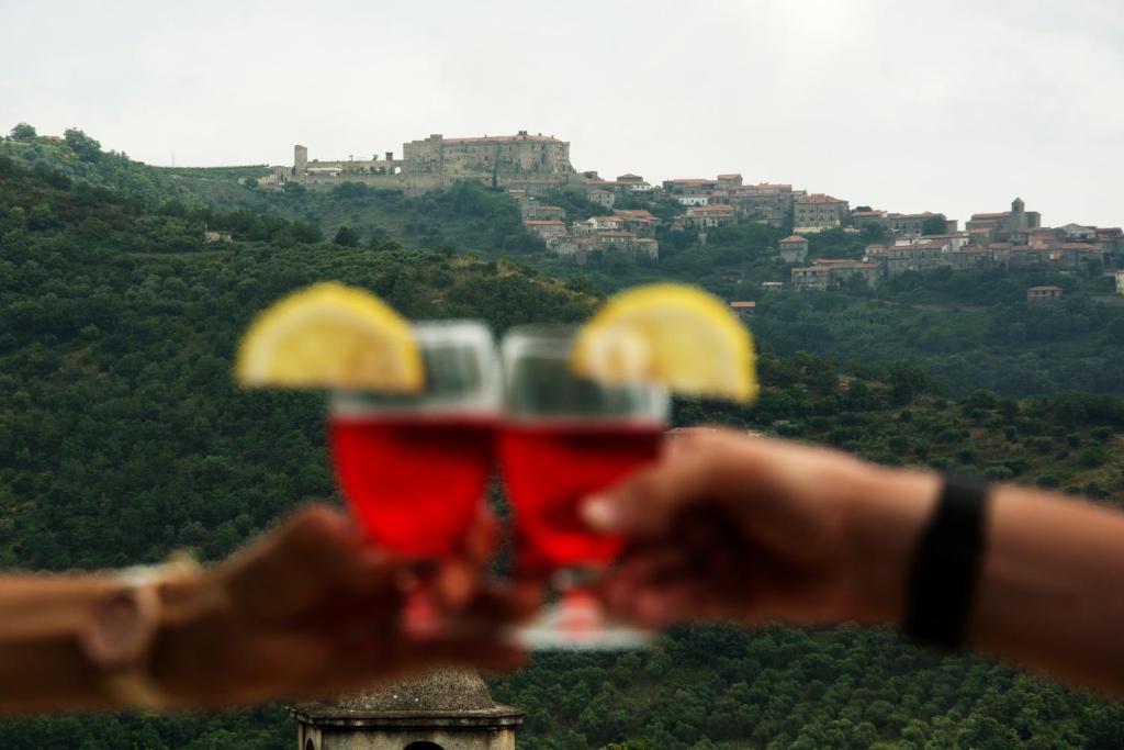 deux personnes tenant des boissons avec une ville en arrière-plan dans l'établissement Casa Vacanze Giuliana, à Casigliano