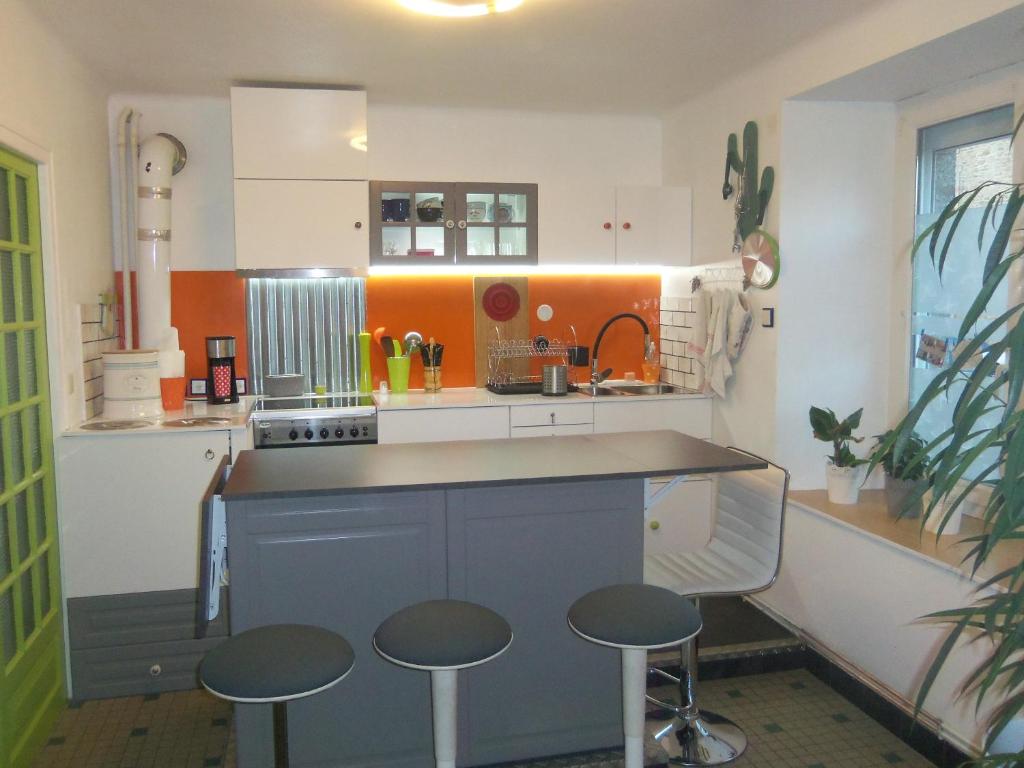 Una cocina con encimera y taburetes. en Gîte familial, en Plouguenast Langast