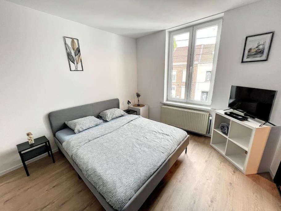 a bedroom with a bed and a flat screen tv at Station 173 D Bruxelles-charleroi-airport in Charleroi