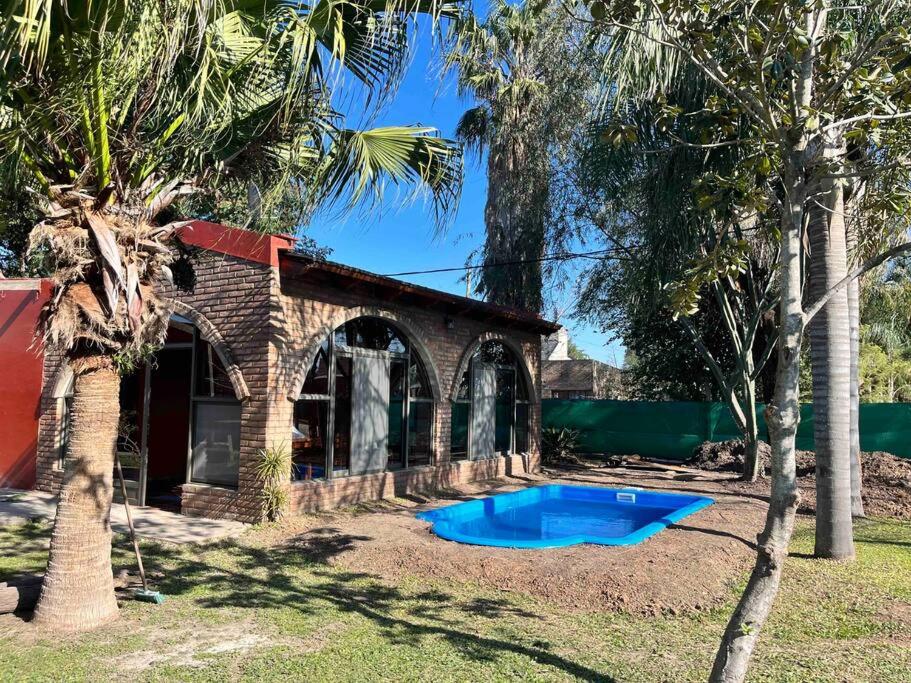 una casa con una piscina azul en el patio en La casa del Rio en Sauce Viejo - Santa Fe- en Sauce Viejo