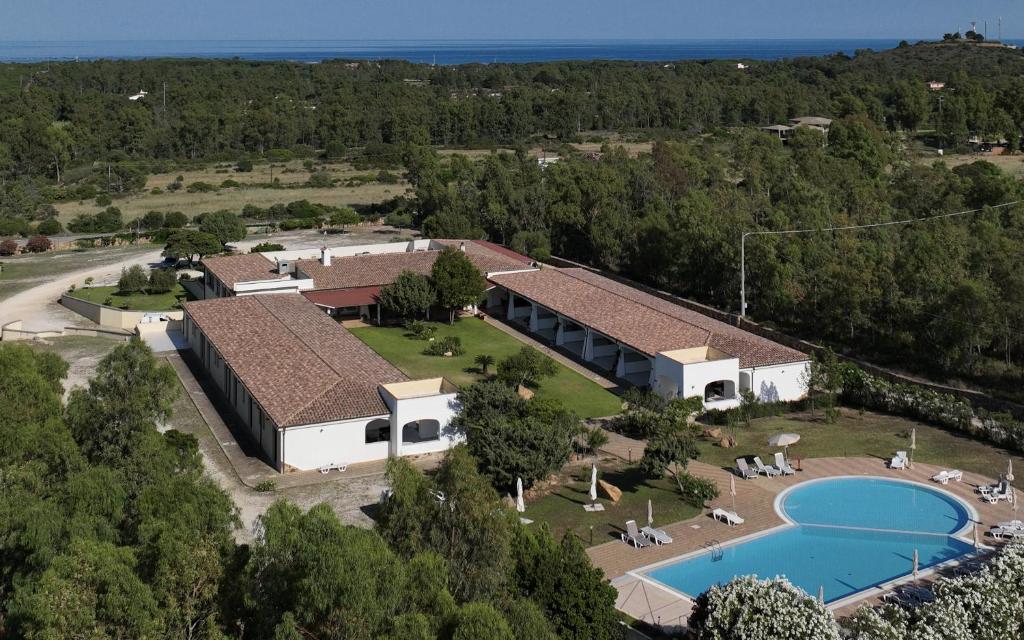 eine Luftansicht eines Hauses mit Pool in der Unterkunft Hotel Biderrosa in Cala Liberotto