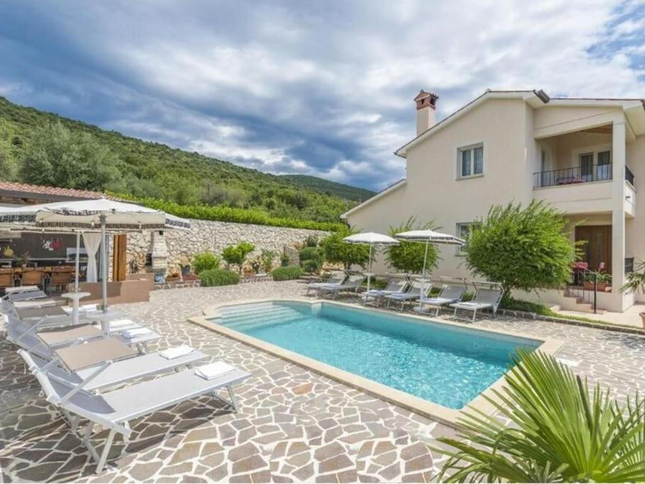 a villa with a swimming pool and a house at Villa Tomko in Brovinje