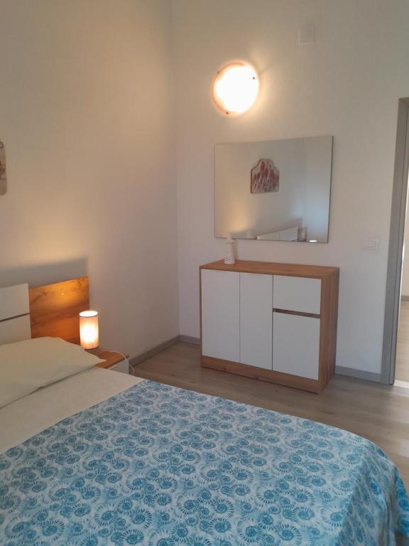 um quarto com uma cama, uma cómoda e um espelho em Casa vicino al mare em Piombino