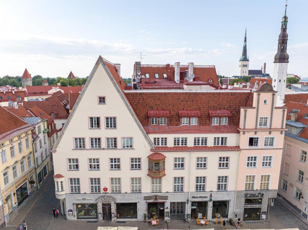 a large white building with red roofs in a city at Old Town - Hall Square Apartment in Tallinn