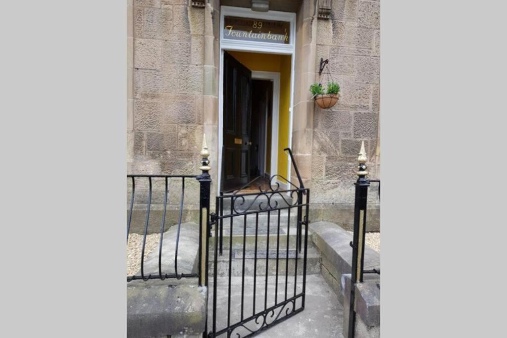 a black iron gate in front of a door at Snug - Fountain Bank Apartment in Helensburgh