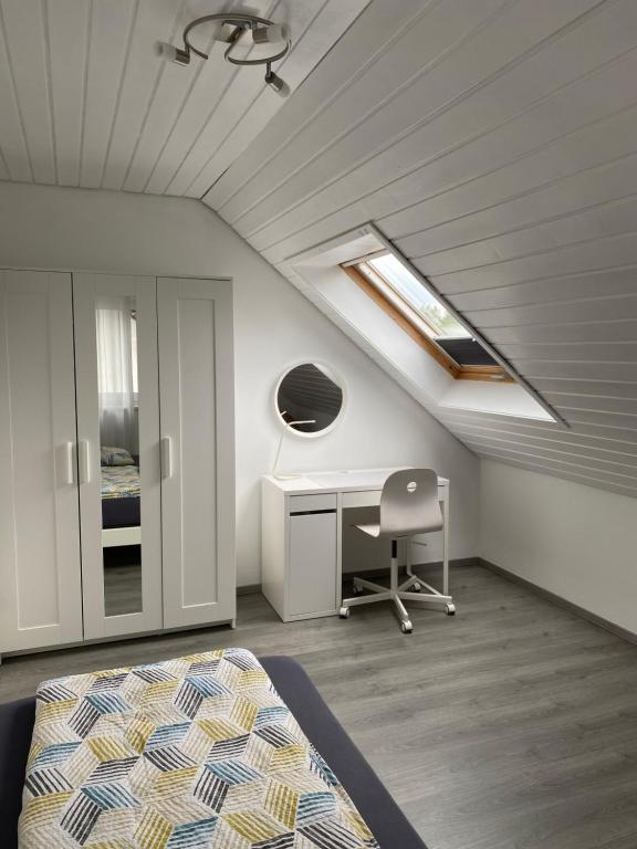 a bedroom with a bed and a desk and a window at Seeglück22 in Reichenau