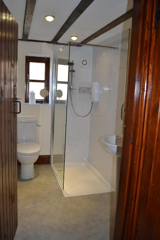 a bathroom with a glass shower and a toilet at Lodge Barns in Fiskerton