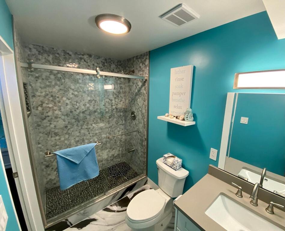 a bathroom with a shower with a toilet and a sink at Luxury 2bed 2bath Condo In Downtown Red Hook in St Thomas