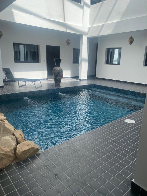 a swimming pool with blue water in a building at Appartement 1 Riad Dar Samar in Tamraght Ouzdar