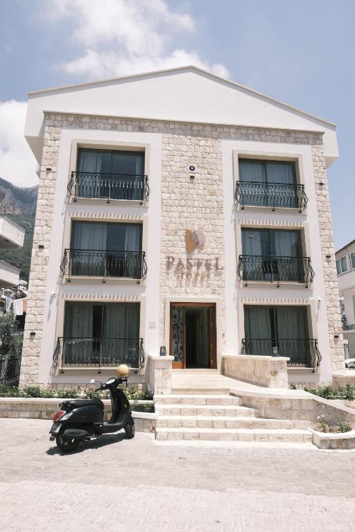 un scooter estacionado frente a un edificio en Hotel Pastel Kaş en Kas