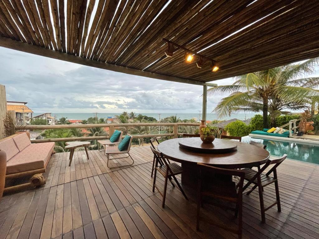 une terrasse avec une table, des chaises et une piscine dans l'établissement Taiba Desert Point, à Taíba