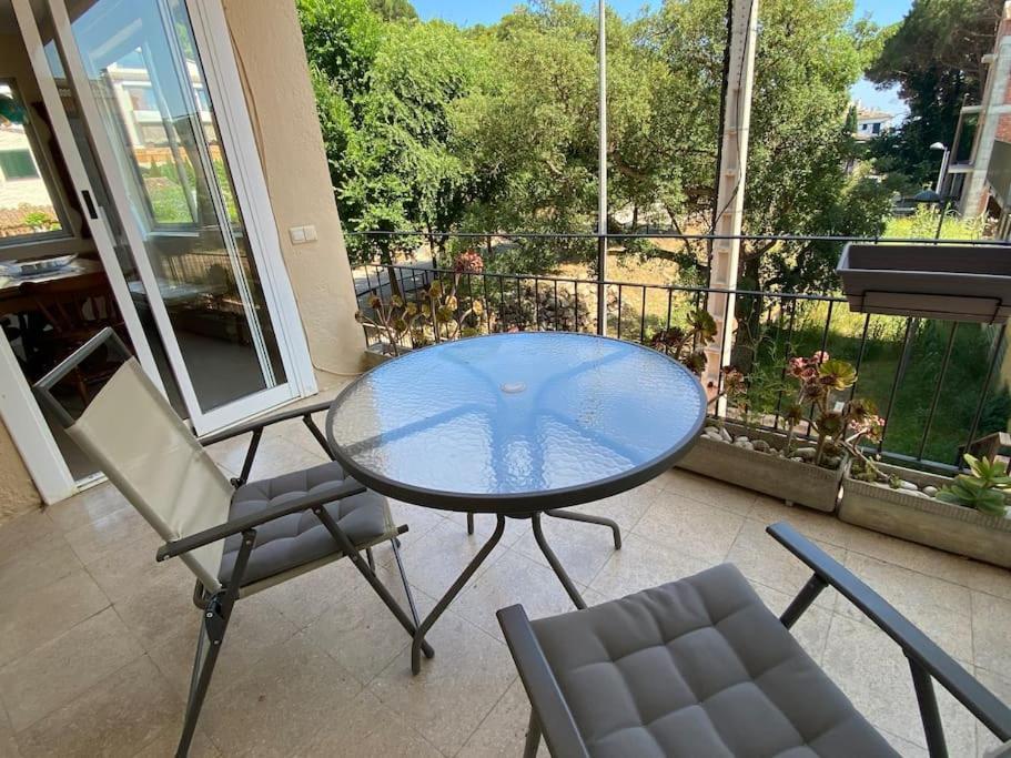 d'une table et de chaises en verre sur le balcon. dans l'établissement Llafranc, soleado, 5 p, a 200 metros de la playa, à Llafranc