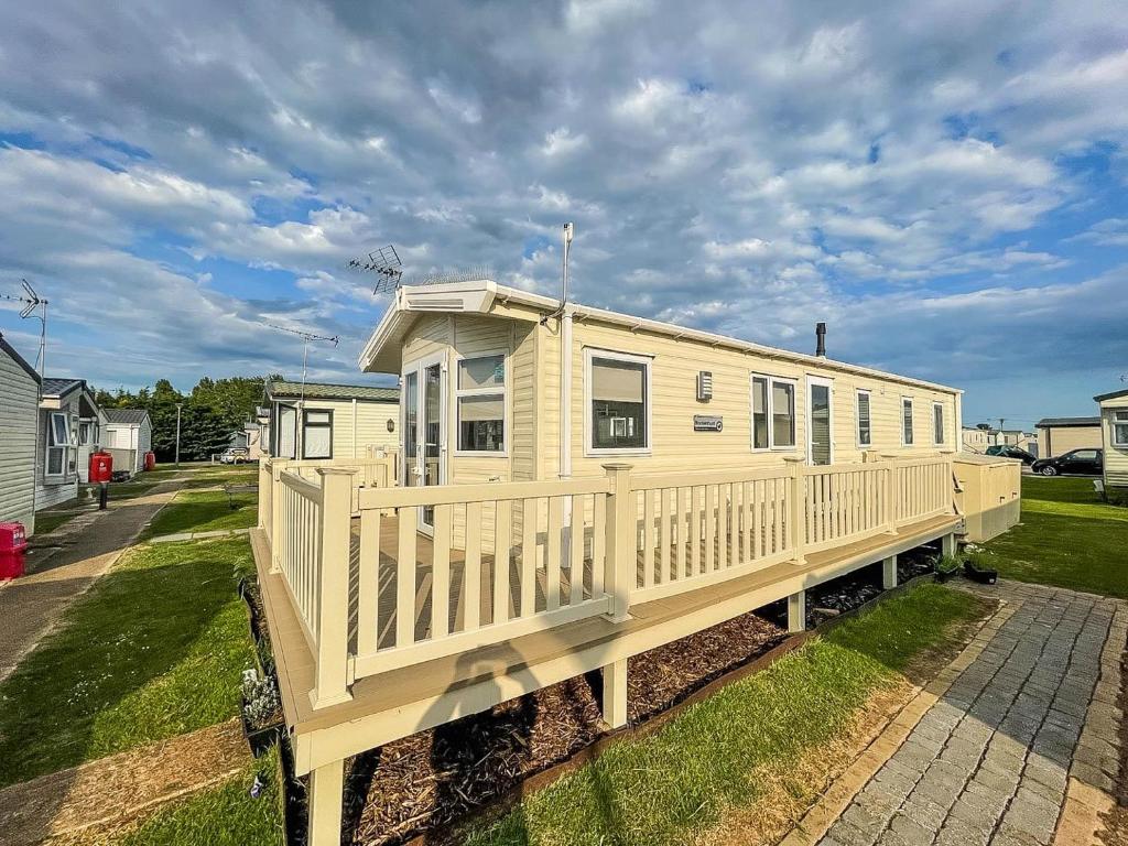 ein modulares Haus mit einer Veranda auf einer Terrasse in der Unterkunft Caravan With Decking And Free Wifi At Seawick Holiday Park Ref 27214sw in Clacton-on-Sea