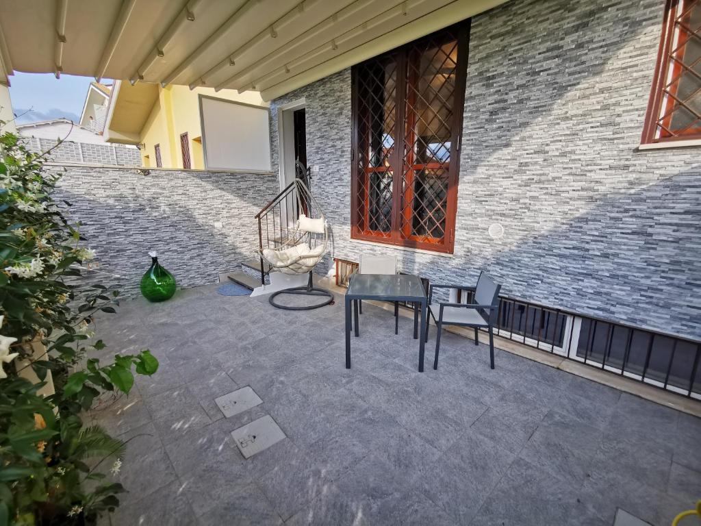 patio ze stołem i krzesłami obok ceglanego budynku w obiekcie Via Subiaco guest house w mieście Marco Simone