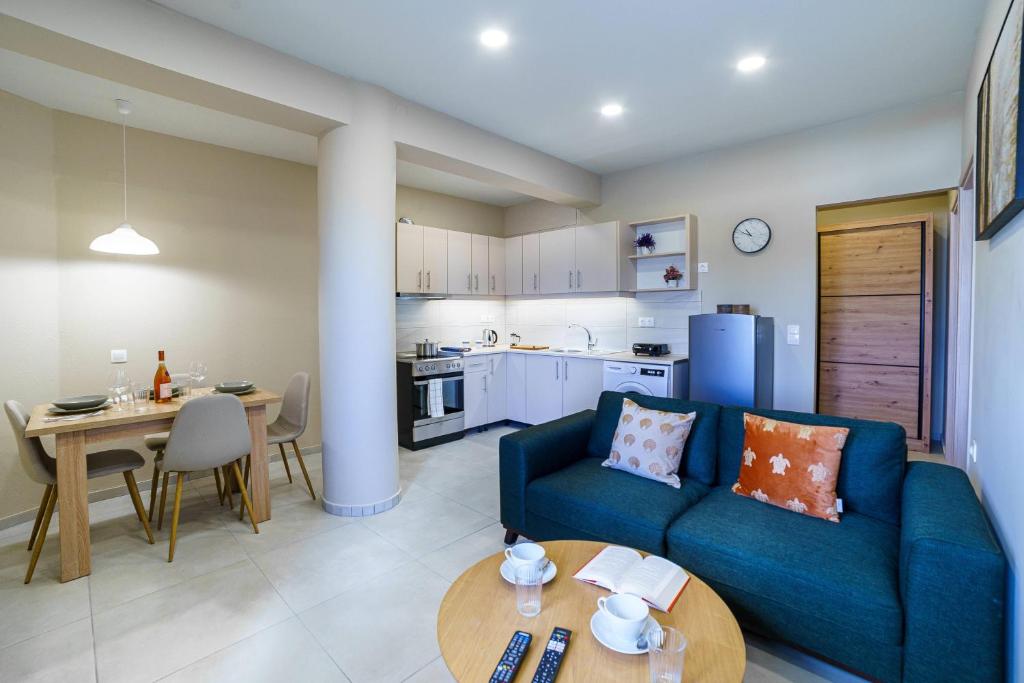 a living room with a blue couch and a table at Palm home 1 in Makry Gialos