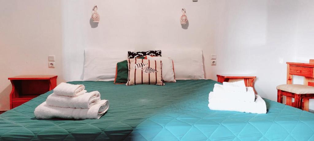 a bedroom with a large green bed with towels on it at Aris House - Cretan Hospitality in Agios Nikolaos