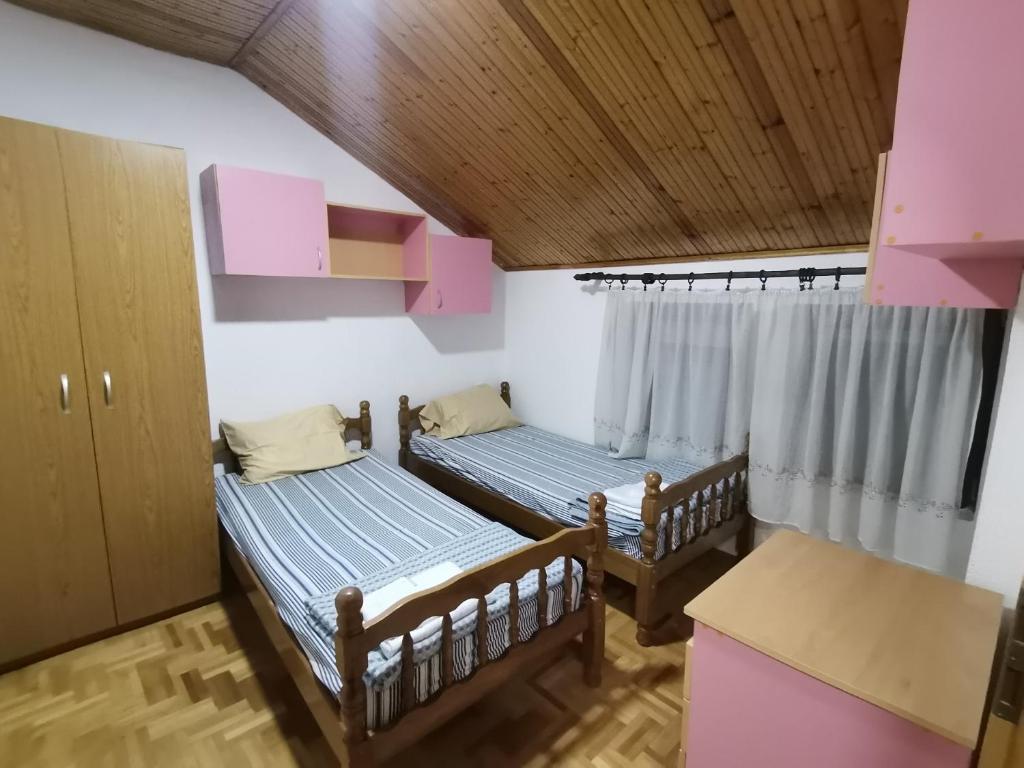 two beds in a room with a window at IS Guest House in Ohrid