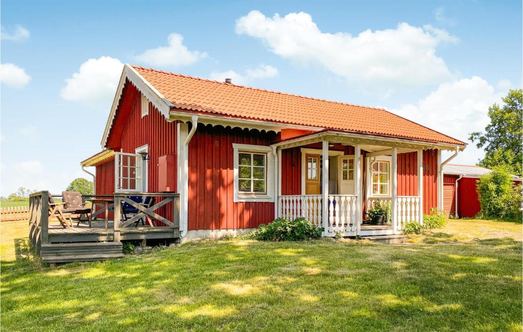 ein rotes Haus mit einem Zaun und einem Hof in der Unterkunft Stunning Home In Kalmar With Kitchen in Kalmar
