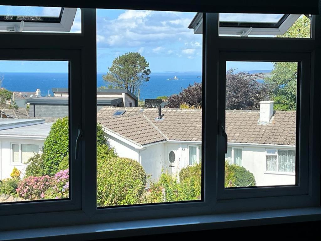 una ventana de una casa con vistas en Godrevy Lighthouse View, Carbis Bay, St Ives, free parking near beach en Carbis Bay