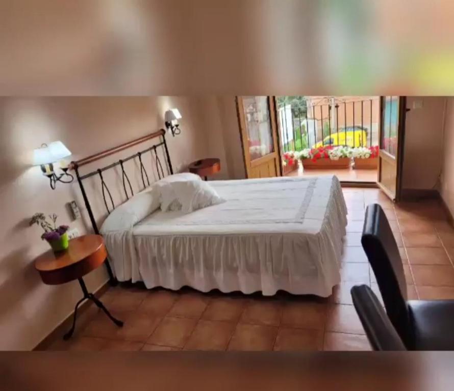 um quarto com uma cama, uma mesa e uma janela em Hotel Rural Cristania em Caminomorisco