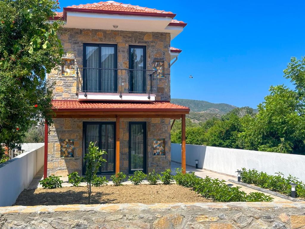 a brick house with a balcony on top of it at Villa Seray Datça in Datca