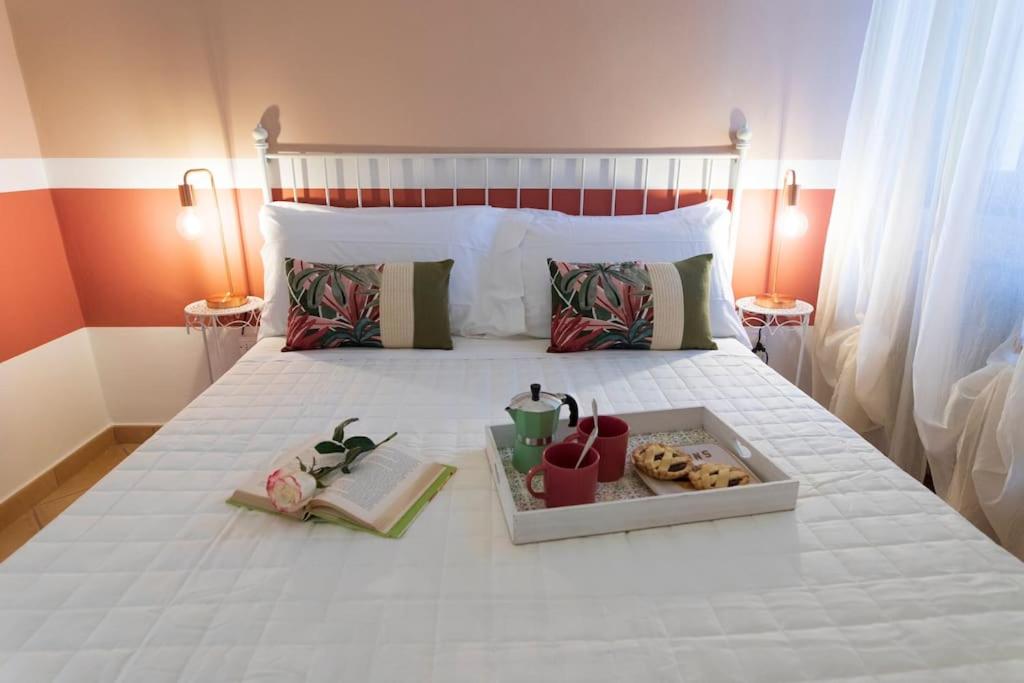 a white bed with a tray of donuts on it at Vaccaj Home cultura musica e mare a Pesaro by Yohome in Pesaro