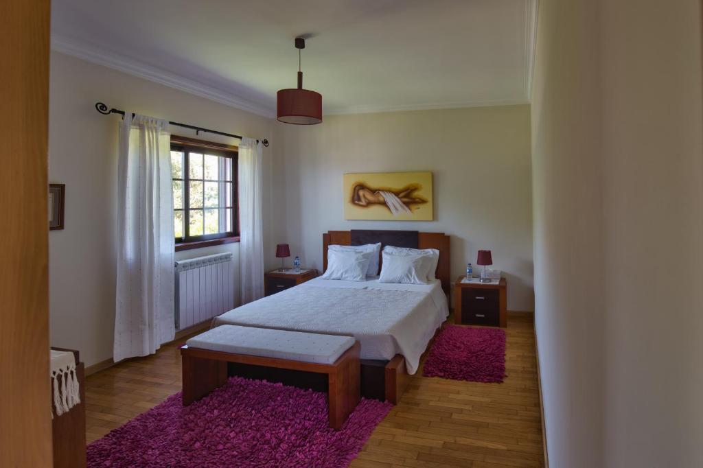 a bedroom with a bed and a purple rug at Suite em Viana do Castelo in Viana do Castelo
