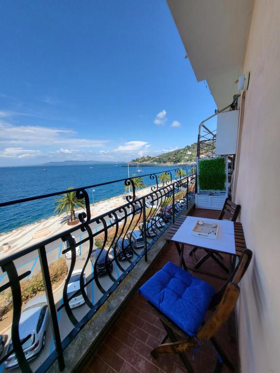 balcone con sedie, tavolo e spiaggia di Tocco di mare a Porto Santo Stefano