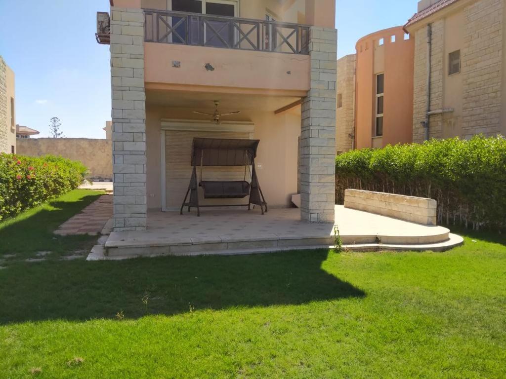 una sedia seduta su un patio di fronte a una casa di 4 bedroom Villa with private terrace, pool, and garden ad Al Ḩammām