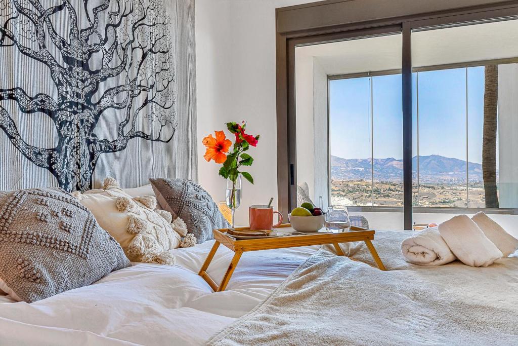 a bedroom with a white bed with a table on it at Calita 109 Mijas Costa - Málaga in La Cala de Mijas