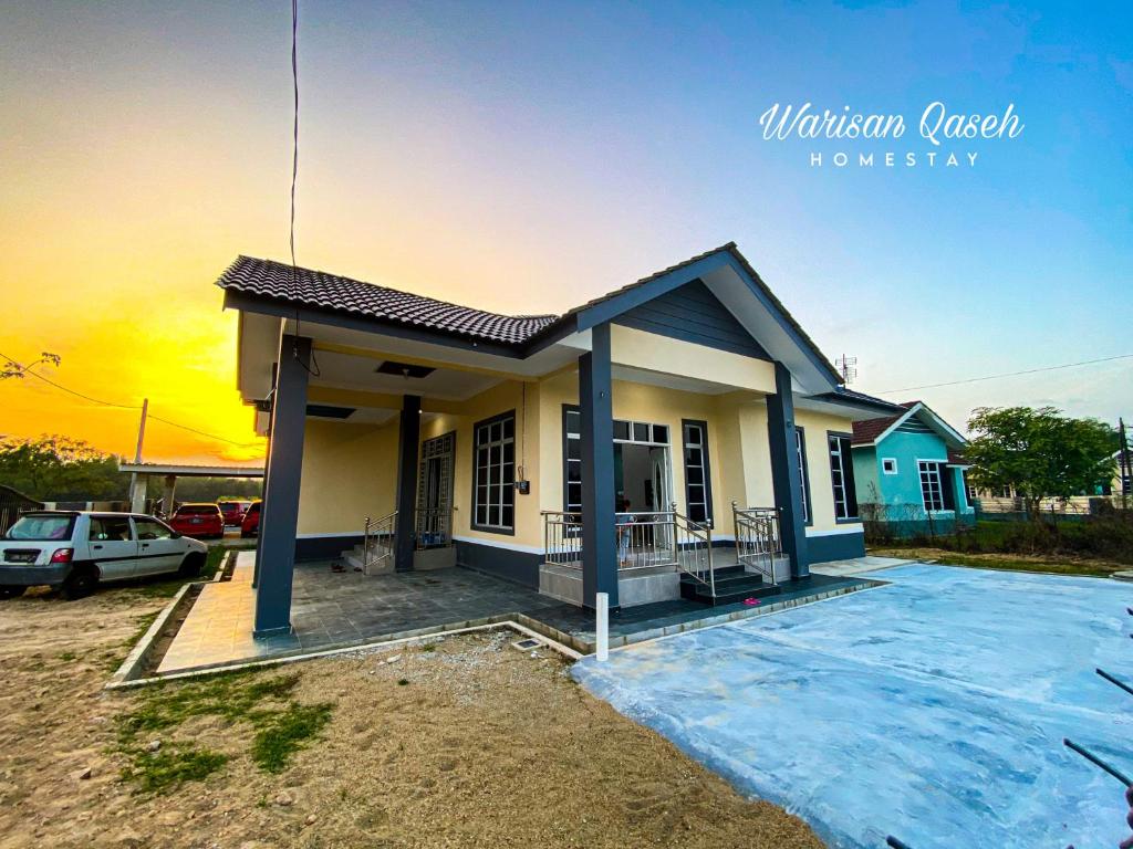 una casa en construcción con la puesta de sol en el fondo en Warisan Qaseh Homestay en Tanah Merah