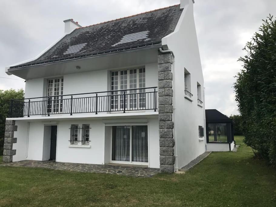 a white house with a balcony on the side of it at Villa Mer, Campagne et départ de randonnées in Moëlan-sur-Mer