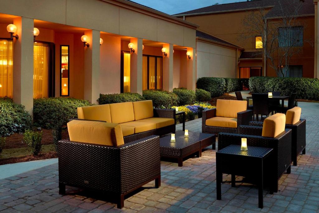 a patio with chairs and tables and a building at Courtyard Birmingham Hoover in Hoover