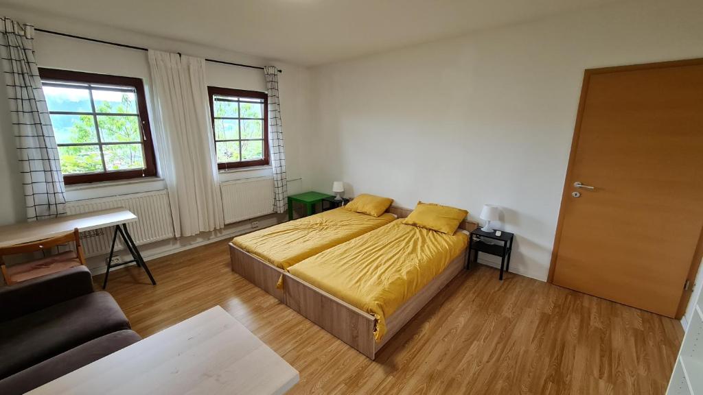 een slaapkamer met een bed met gele lakens en een bank bij Apartma pri babici in Slovenj Gradec