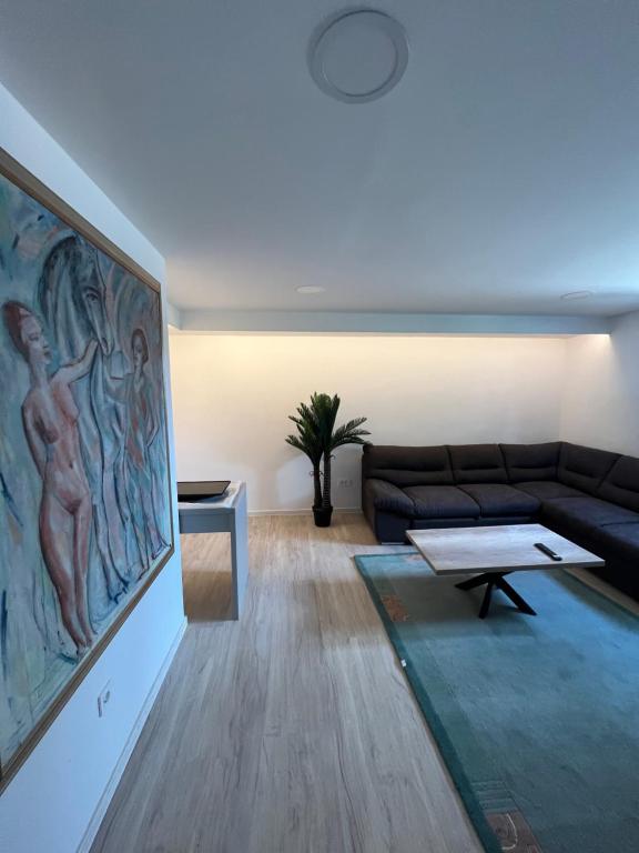 una sala de estar con sofá y una pintura en la pared en The Nice Apartment, en Domžale