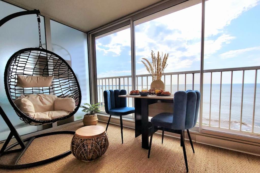 a room with a table and chairs and a large window at Magnifique Studio 2 personnes - VUE MER "La Perle de Jade" in Saint-Michel-Chef-Chef