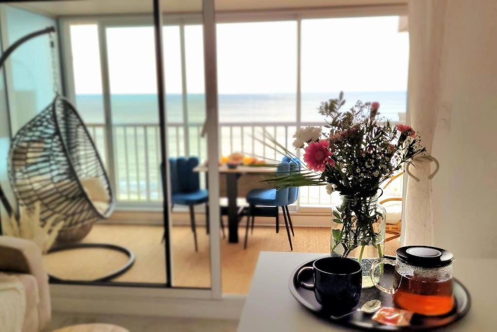 a living room with a table with a vase of flowers at Magnifique Studio 2 personnes - VUE MER "La Perle de Jade" in Saint-Michel-Chef-Chef
