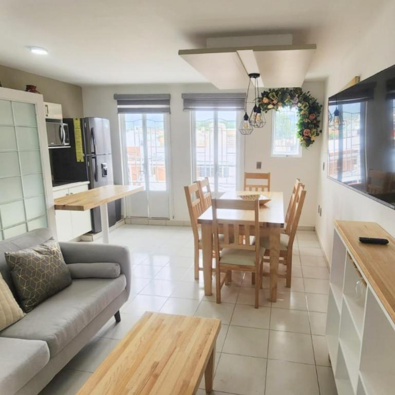 San Juan Apartament في اروابان دل بروغرسو: مطبخ وغرفة معيشة مع طاولة وكراسي