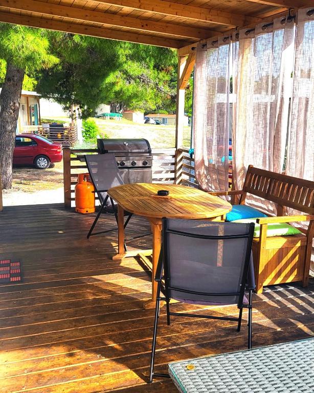 a wooden table and chairs on a deck at Mobile Homes Aurea Maris - Kamp Dole Živogošće in Živogošće
