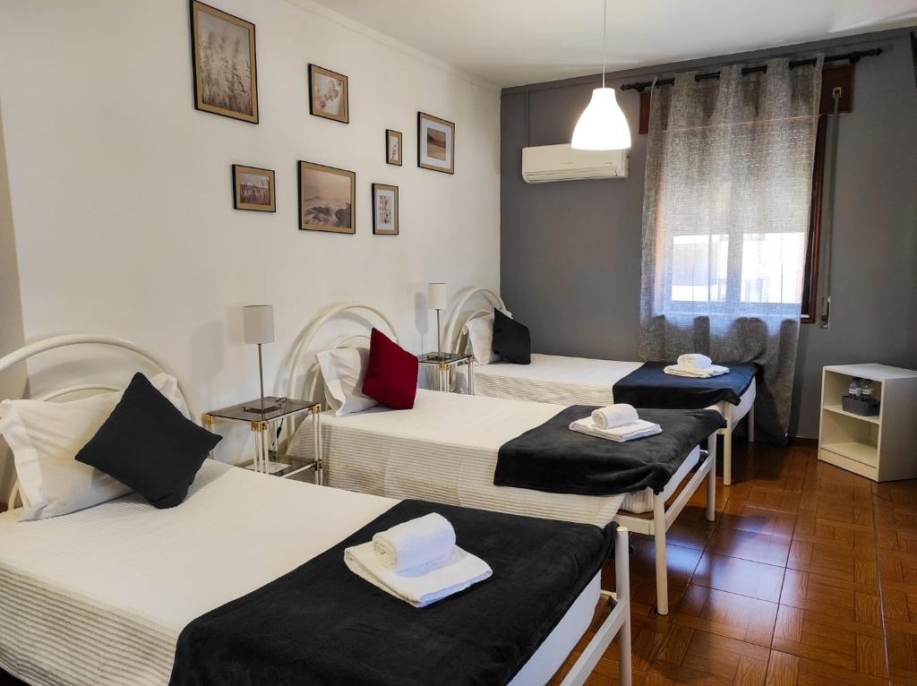 um quarto com três camas com toalhas em Alojamento Local Tamega em Amarante