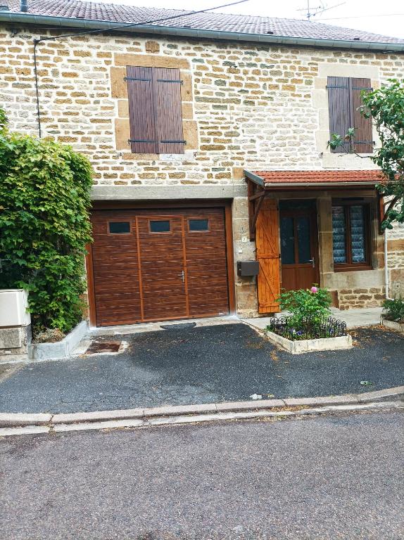 une maison avec deux portes de garage en bois dans l'établissement L'annexe, à Chalindrey