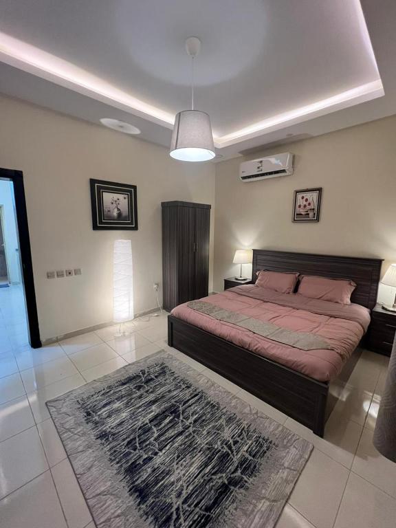 a bedroom with a large bed and a rug at الدمام حي مدينة العمال الشارع العاشر in Dammam