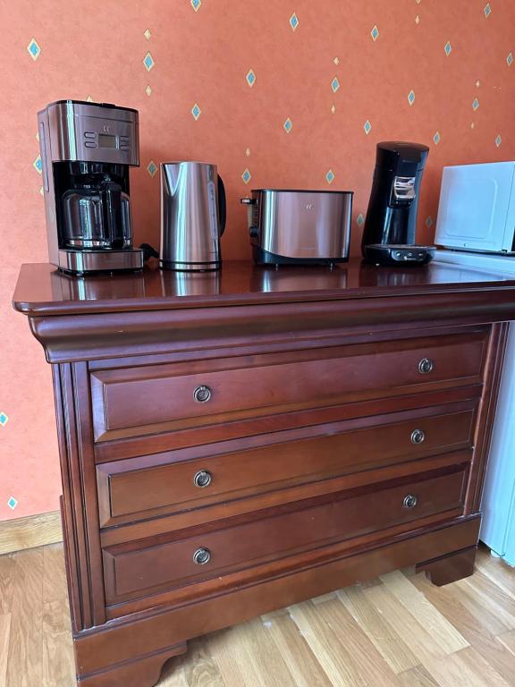 a wooden dresser with a coffee maker on top of it at Les Combes in Murat-le-Quaire